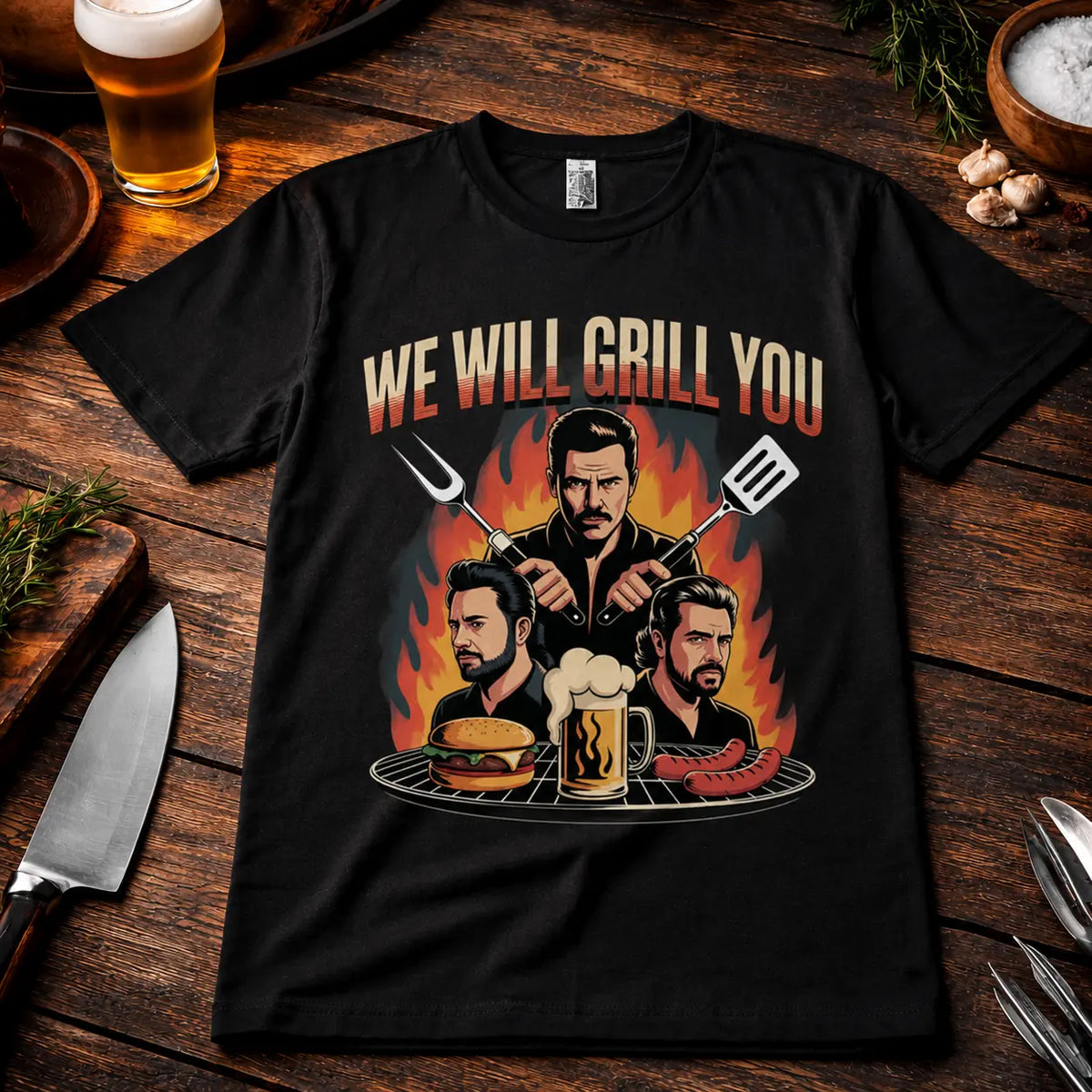 Meatware We Will Grill You T-Shirt mit humorvollem Rock-inspiriertem BBQ Design, Grillmeister, Burger, Bier und Würstchen auf schwarzem Shirt im rustikalen Grill-Mockup mit Bier, Kräutern und Grillbesteck.